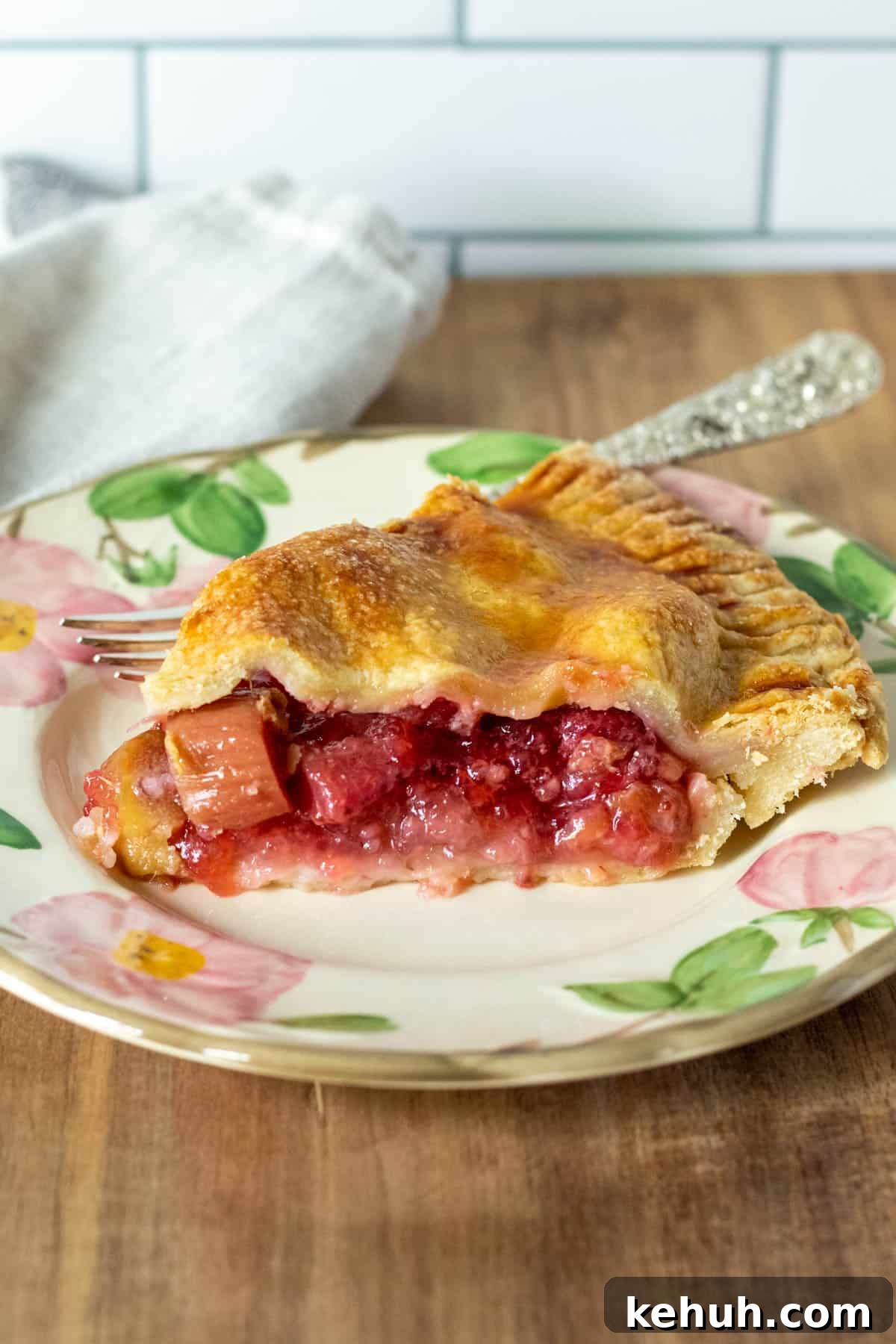 Side view of piece of pie on flowered plate with fork.