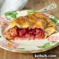 Piece of pie on serving plate with fork.