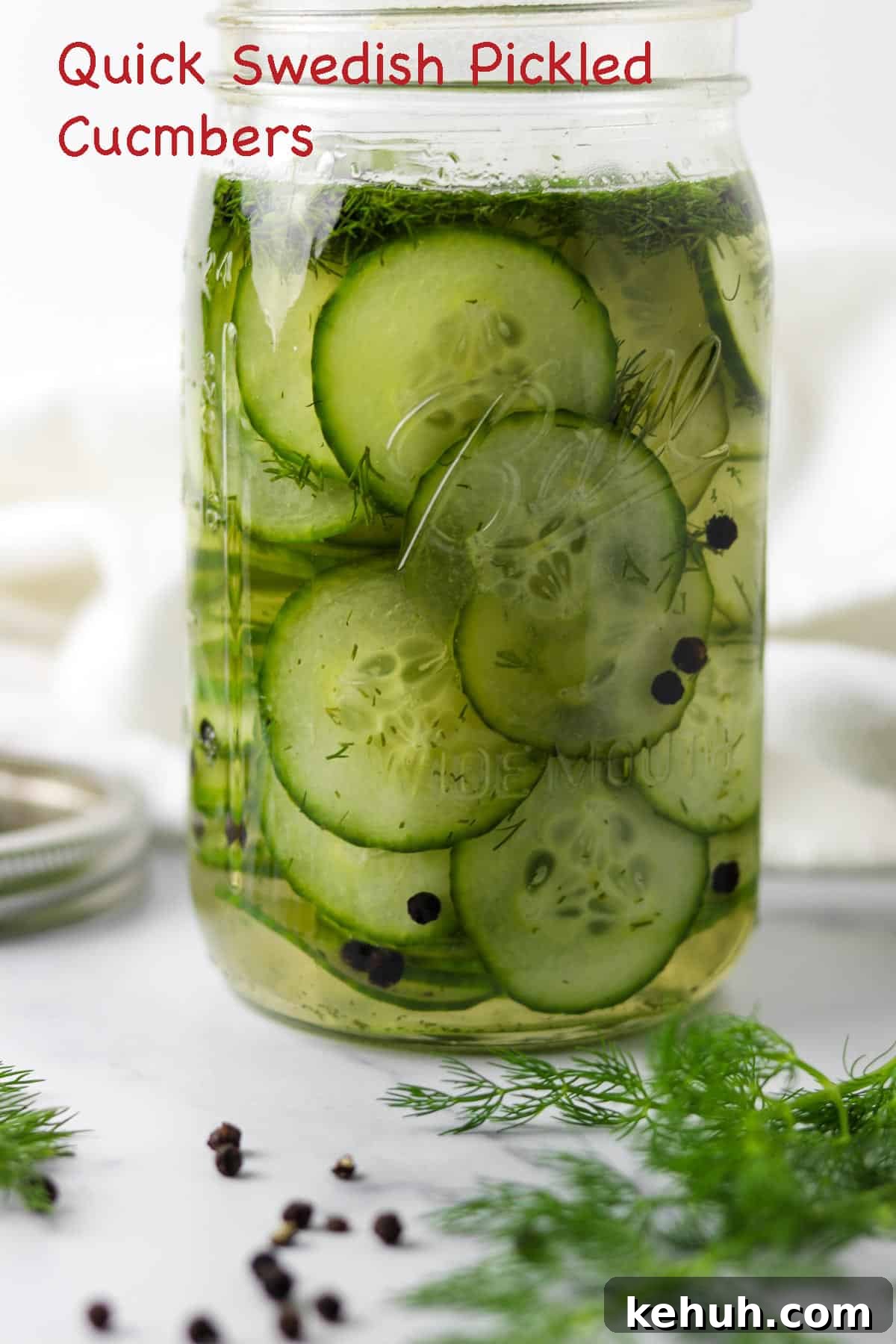 Classic Swedish Meatballs with Creamy Gravy (Köttbullar) 6 Quick Swedish Pickled Cucumbers in a jar next to peppercorns and fresh dill sprigs.