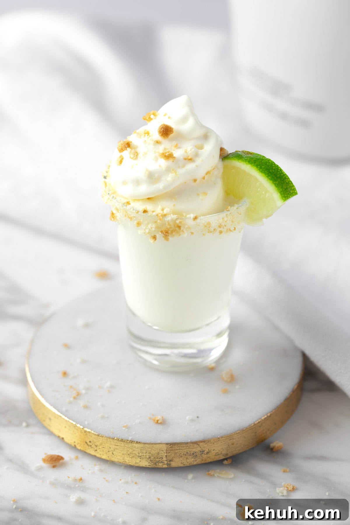 Key Lime Pie Shot Recipe: How to Make the Classic Cocktail Shooter 2 A Key Lime Pie Shot topped with whipped cream, graham cracker sprinkles and a mini slice of lime.