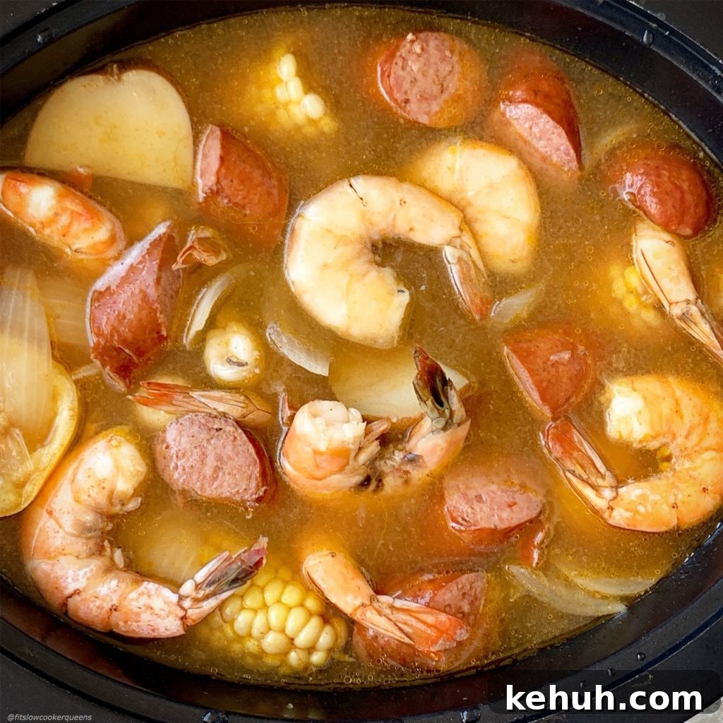 overhead shot of adding cooked seafood boil in a black slow cooker
