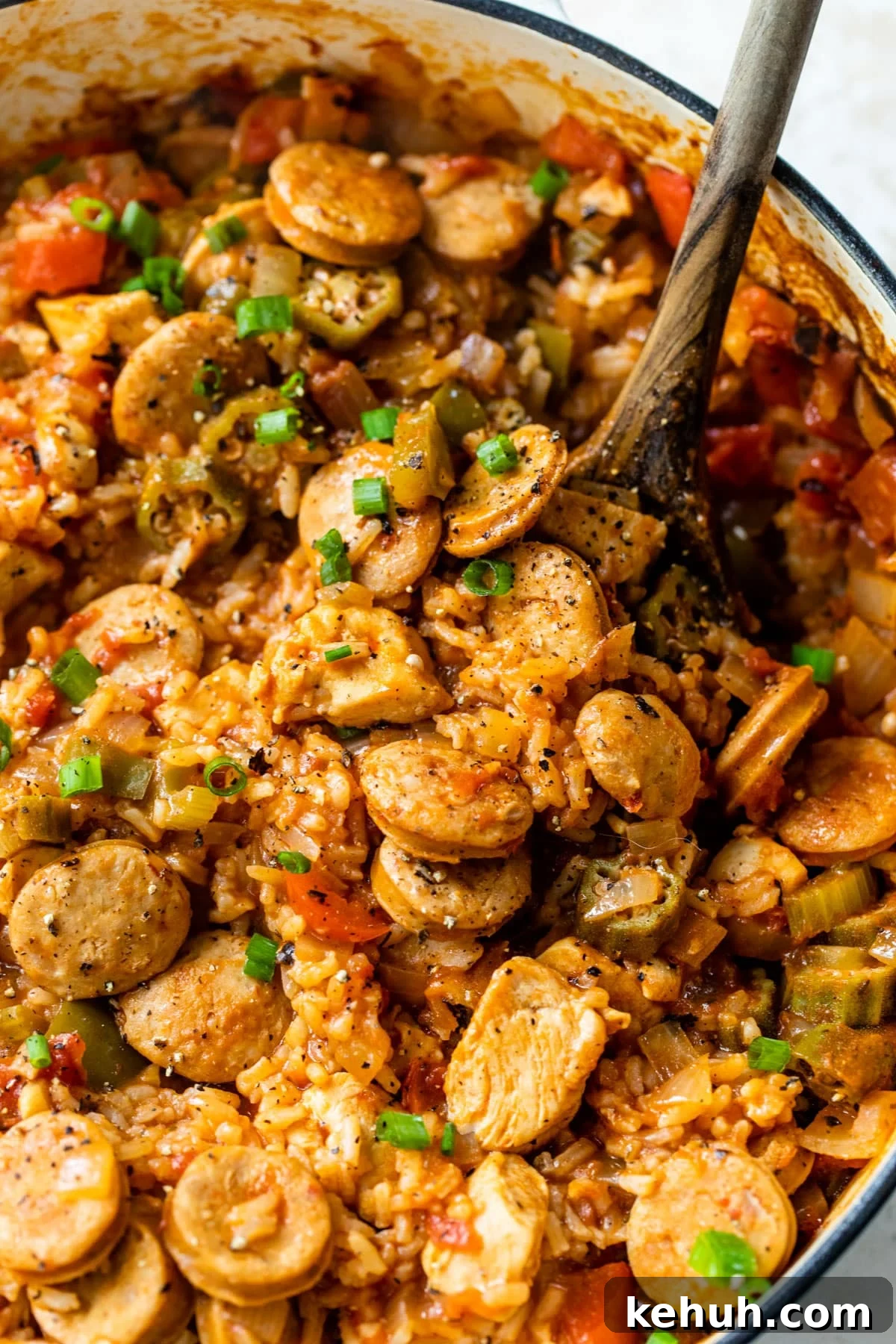 Authentic Chicken and Sausage Jambalaya Recipe for Packed Flavor 2 close-up of chicken and sausage jambalaya in a dutch oven with a wooden spoon