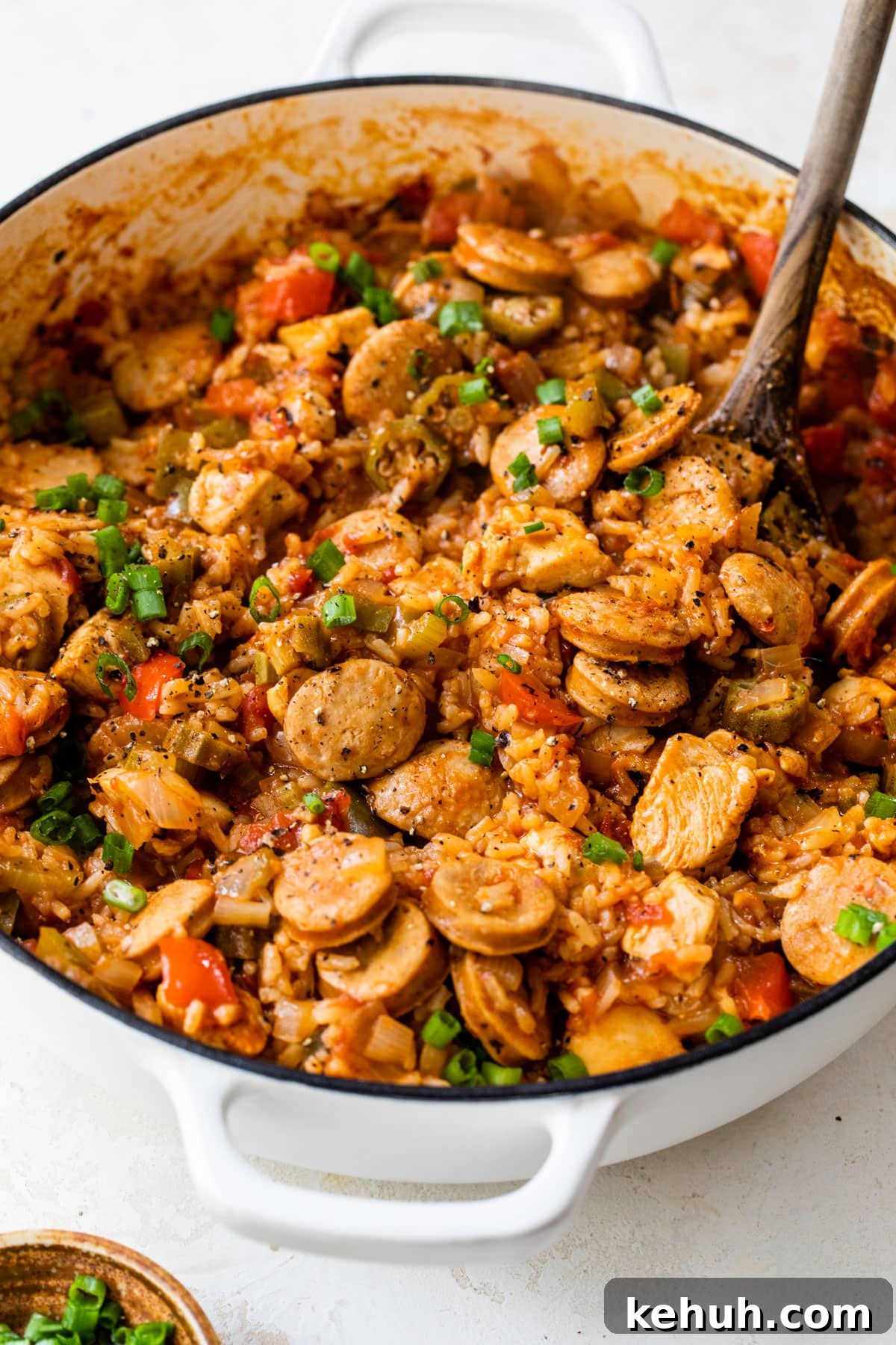 Authentic Chicken and Sausage Jambalaya Recipe for Packed Flavor 6 chicken and sausage jambalaya in a dutch oven with a wooden spoon