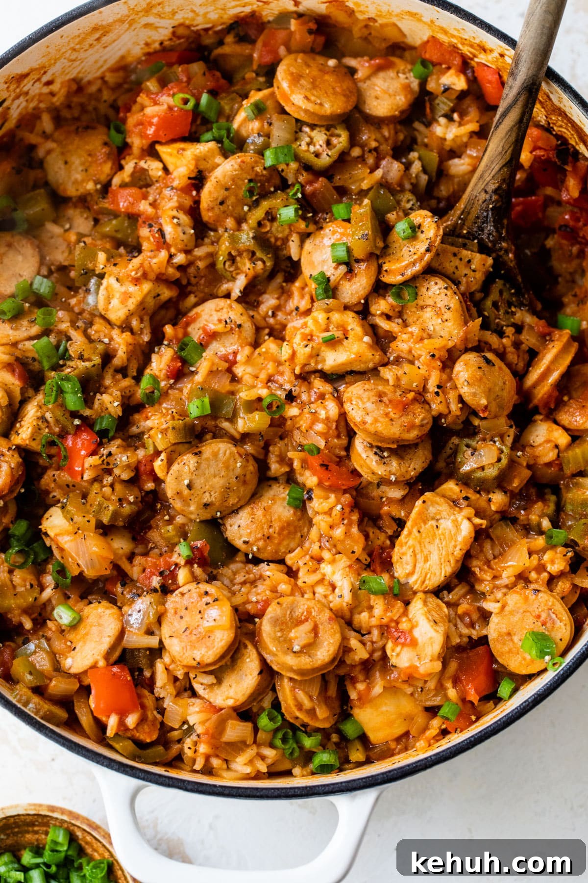 Authentic Chicken and Sausage Jambalaya Recipe for Packed Flavor 7 overview of chicken and sausage jambalaya in a dutch oven with a wooden spoon