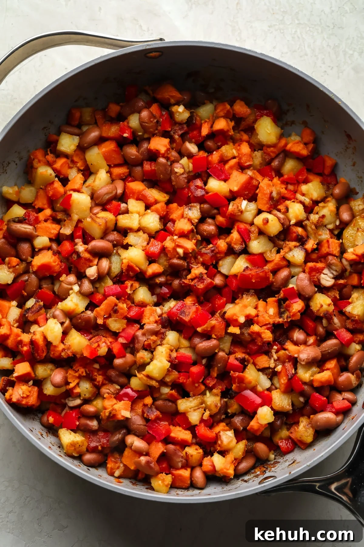High-Protein Vegan Breakfast Burritos for Busy Mornings 3 breakfast hash in pan with sweet and regular potatoes, red pepper and beans