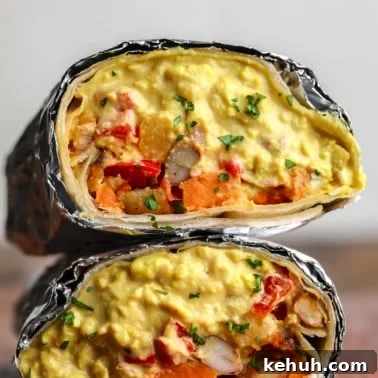 square image of a close up vegan breakfast burrito with eggy mixture and potato veggies