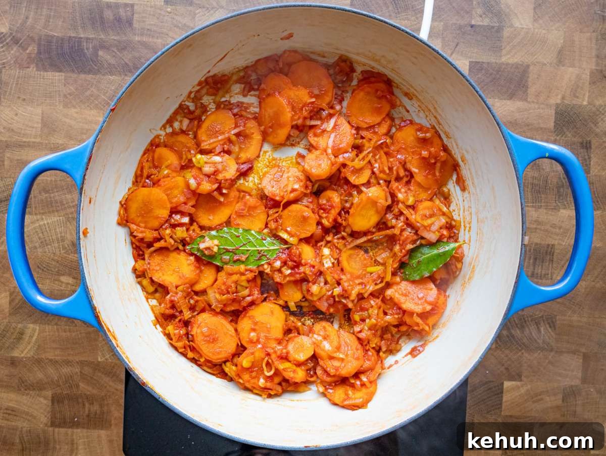 Authentic Greek Lentil Soup (Fakes) — Simple, Flavorful Recipe 5 Step 2 Stirring garlic tomato paste and bay leaves in the pot for flavor.
