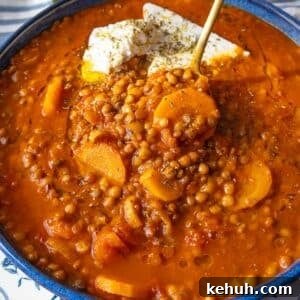 Authentic Greek Lentil Soup (Fakes) — Simple, Flavorful Recipe 8 Warm bowl of Greek lentil soup with carrots and herbs served on a rustic table.