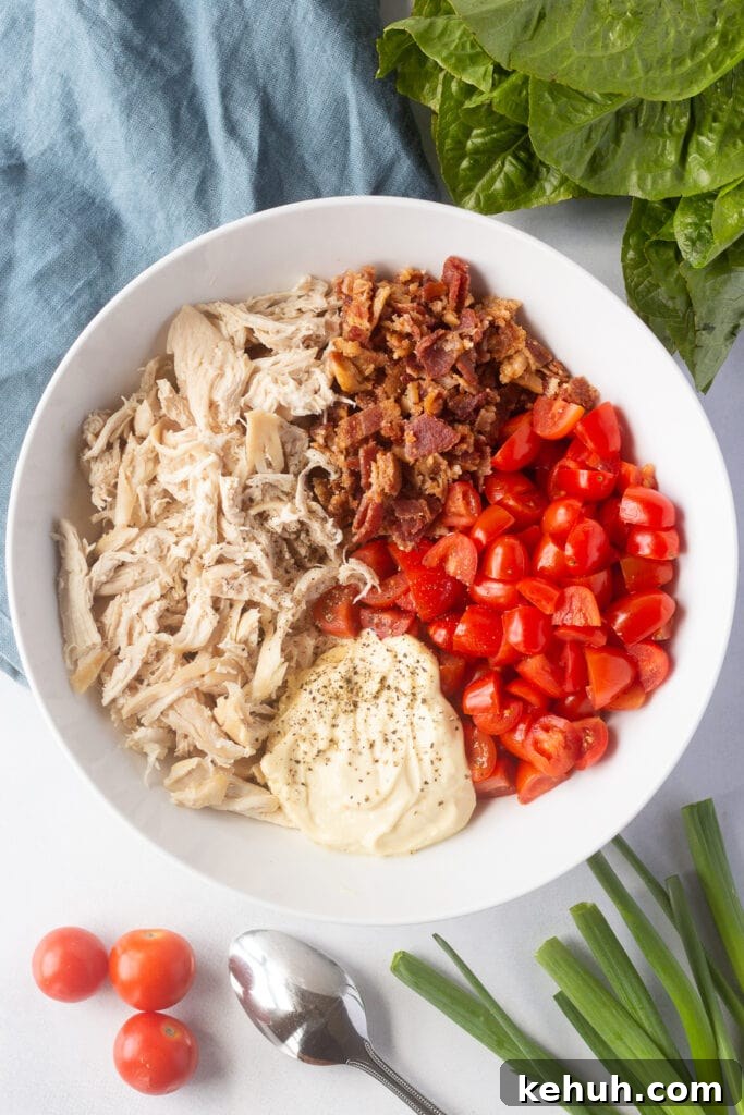 5-Ingredient BLT Chicken Salad Recipe for Quick Lunch 11 Top down shot of ingredients for BLT chicken salad unmixed in a large white bowl.
