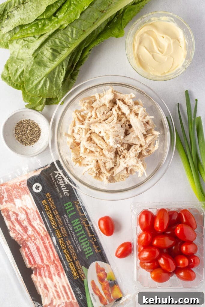 5-Ingredient BLT Chicken Salad Recipe for Quick Lunch 3 top down shot of ingredients for BLT chicken salad on a white background.