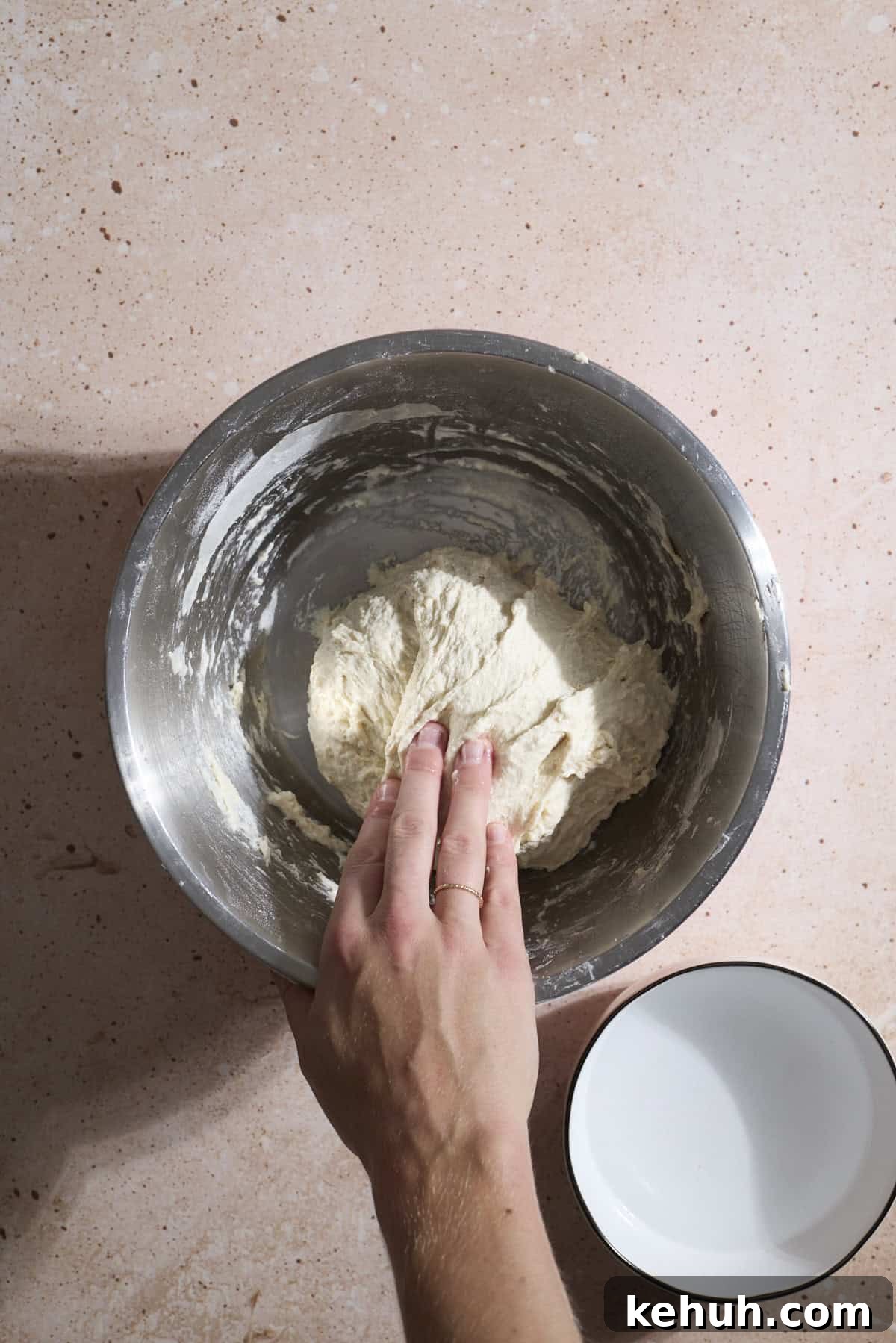 Sourdough Discard Bread Recipe: Crispy Crust, Soft Crumb 5 A hand folding the dough over on itself.