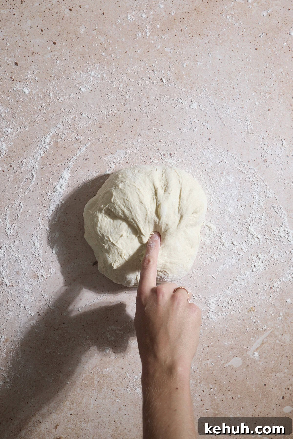 Sourdough Discard Bread Recipe: Crispy Crust, Soft Crumb 8 A hand pulling the dough and folding it over.