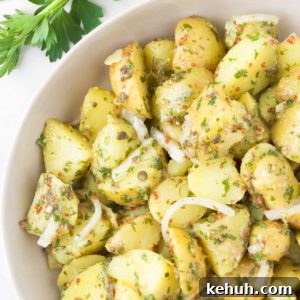 Vegan potato salad in a bowl next to fresh parsley