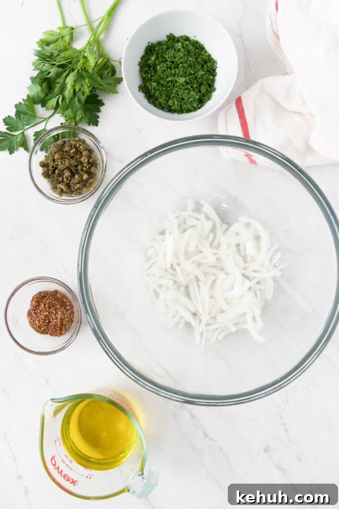 Shaved onions are in a bowl surrounded by bowls of other ingredients