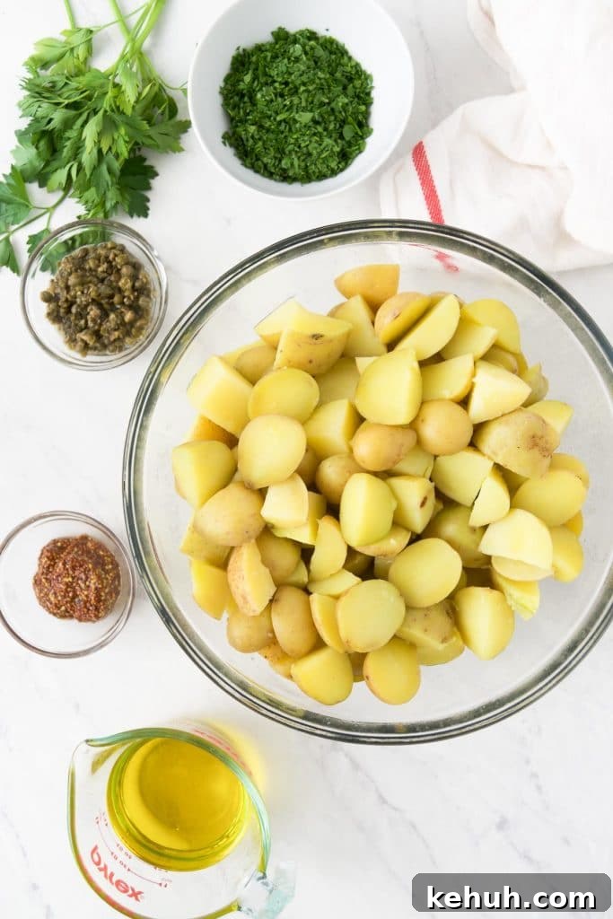 Cooked gold potatoes in a bowl are surrounded by other ingredients
