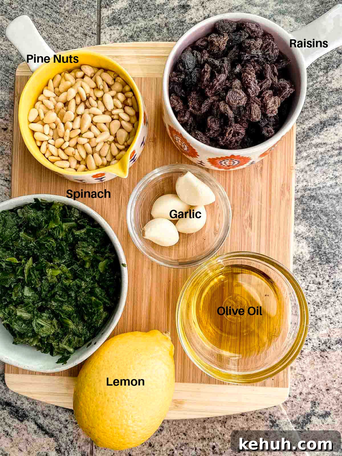 Ingredients to make espinacas a la catalana: spinach, raisins, olive oil, garlic, raisins, pine nuts and lemon 
