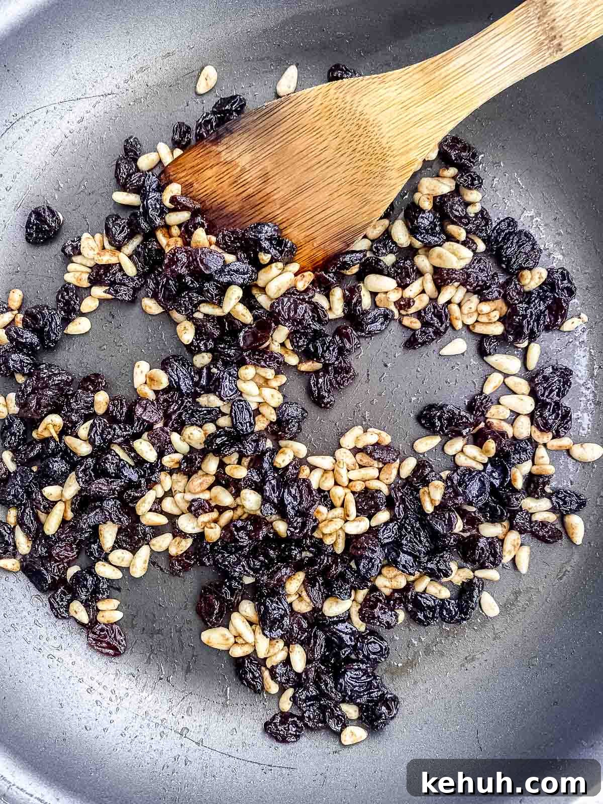 Sauteing pine nuts and raisins in olive oil in a nonstick pan
