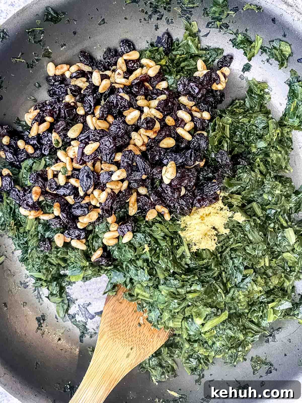 cooked spinach, pine nuts, raisins and lemon zest in a nonstick skillet