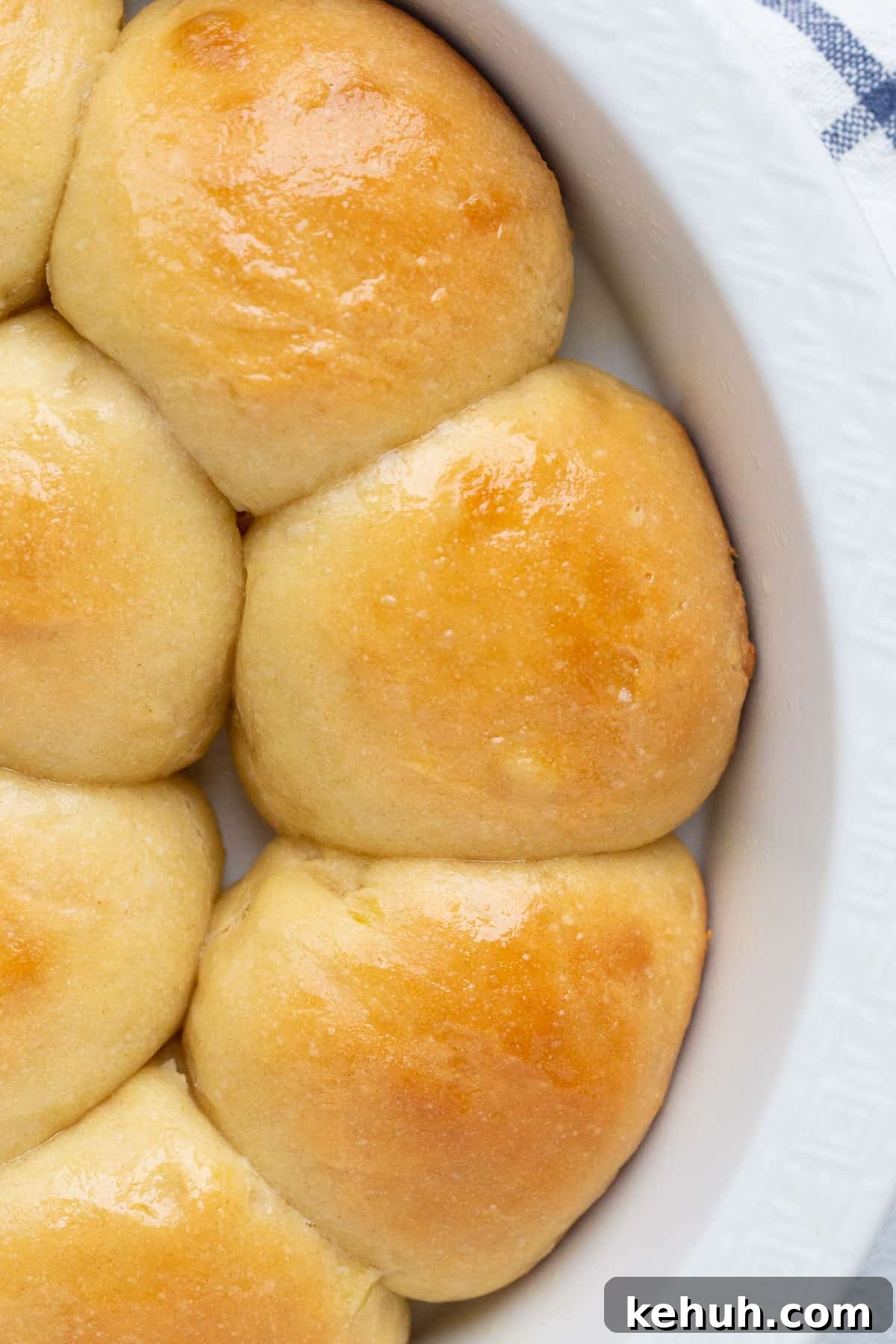 Fluffy Mashed Potato Dinner Rolls: Soft, Buttery Recipe 2 homemade potato rolls in a round white dish.