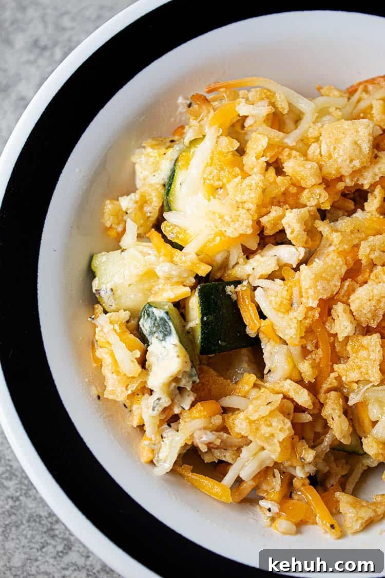 Keto 4th of July Recipes for Your Patriotic Cookout 19 overhead view of serving of healthy keto low carb chicken and zucchini casserole in a white bowl with a black stripped rim