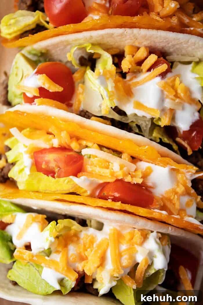 Keto 4th of July Recipes for Your Patriotic Cookout 36 overhead view of 4 tacos with 2 in cheese shells and 2 in tortillas with meat, lettuce, tomato, cheese and avocado