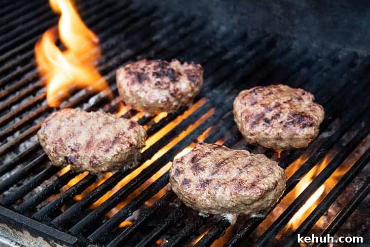 Keto 4th of July Recipes for Your Patriotic Cookout 7 keto burger patties on a grill with a flame