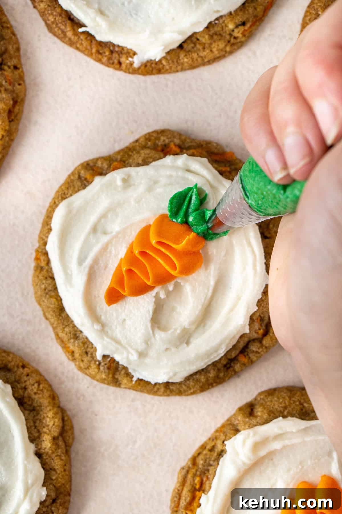 Piping the carrot leaves on the cookies.