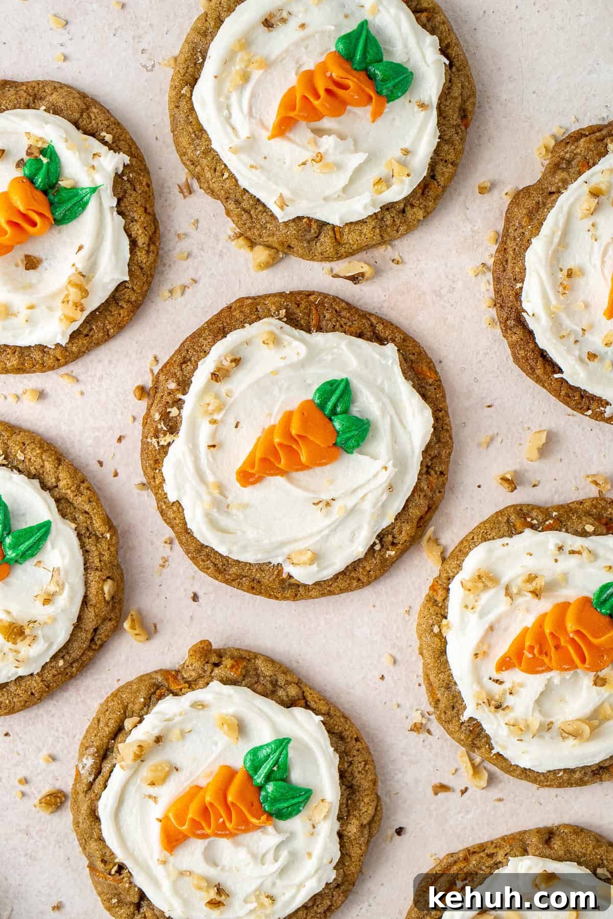 Frosted carrot cake cookies decorate with piped carrots laid out.