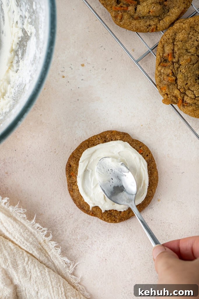 Frosting the carrot cake cookies with buttercream.