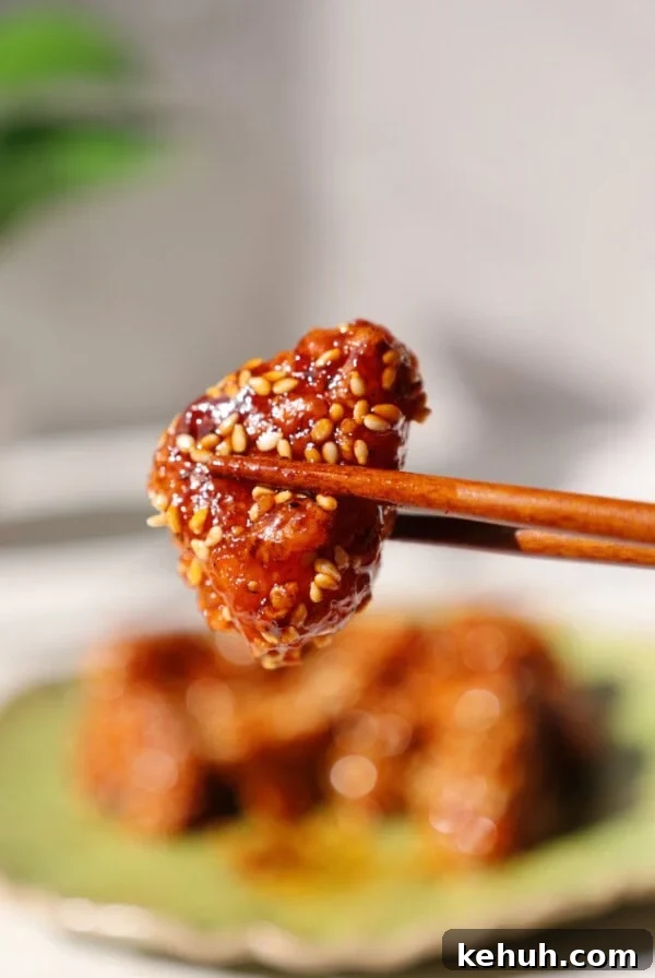 Gochujang tofu being held by chopsticks.