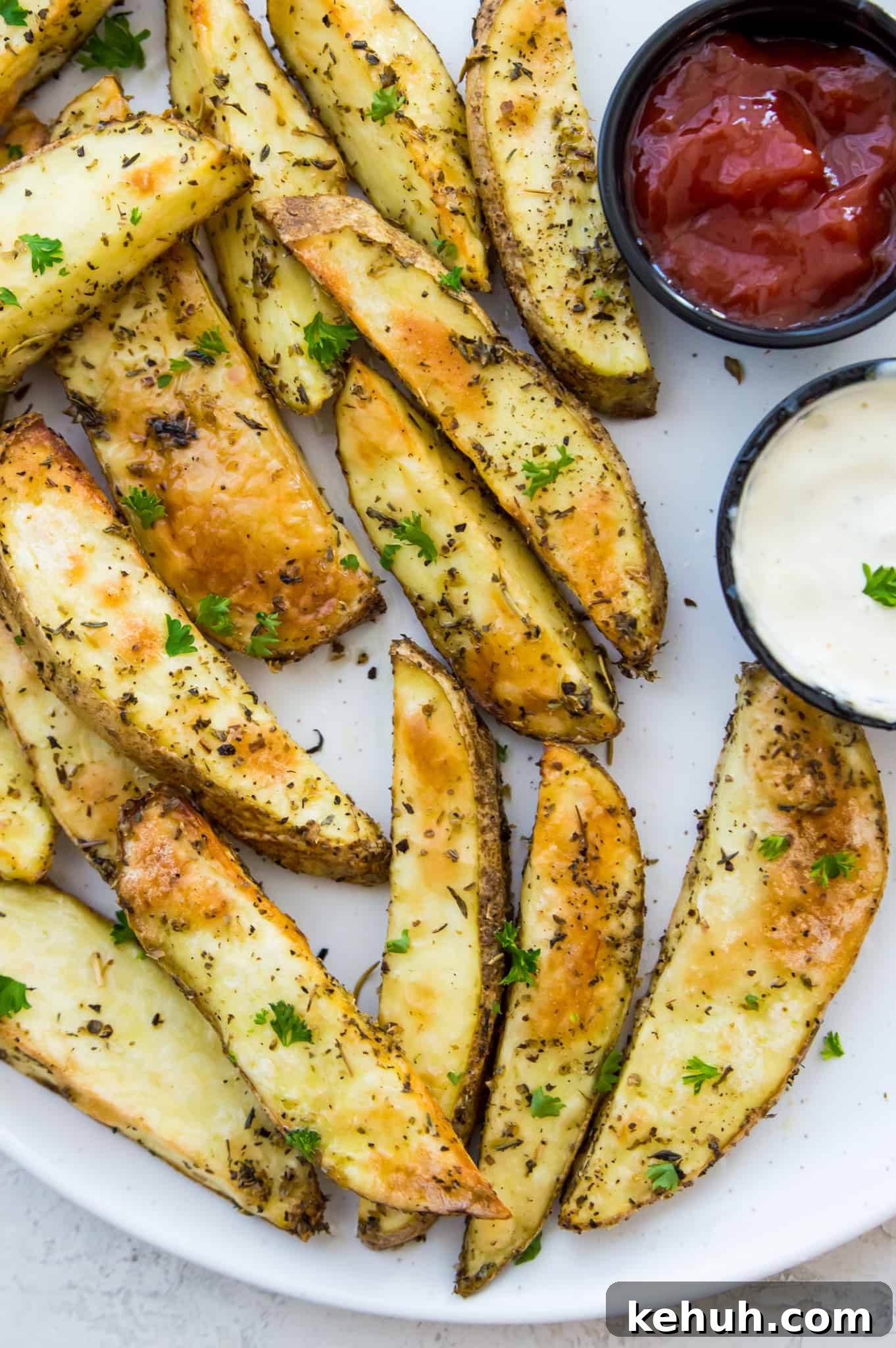A plate of potato wedges that have been cooked in an air fryer with ketchup beside it.
