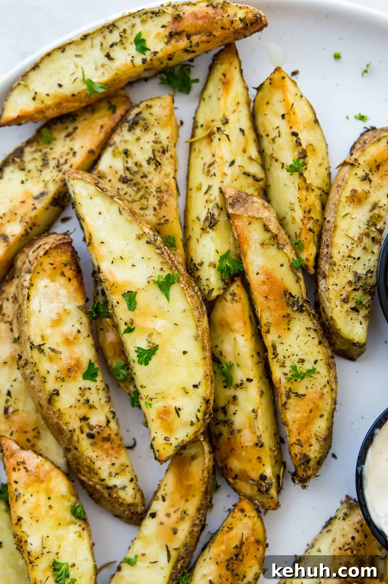 A plate of homemade potato wedges seasoned with fresh parsley .