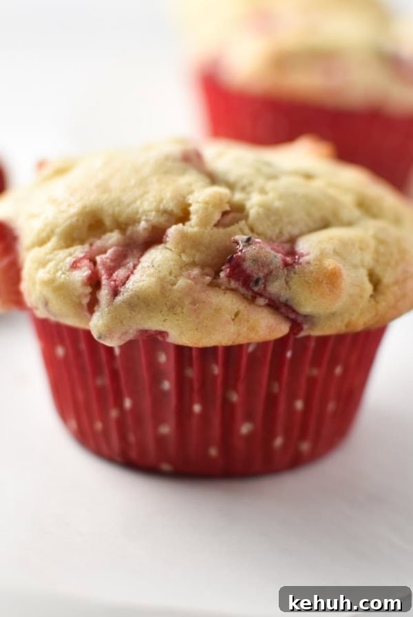 Gluten-Free Strawberry Cupcakes with Cream Cheese Frosting 11 A strawberry cream cheese muffin a red polka dot cup on a white table.