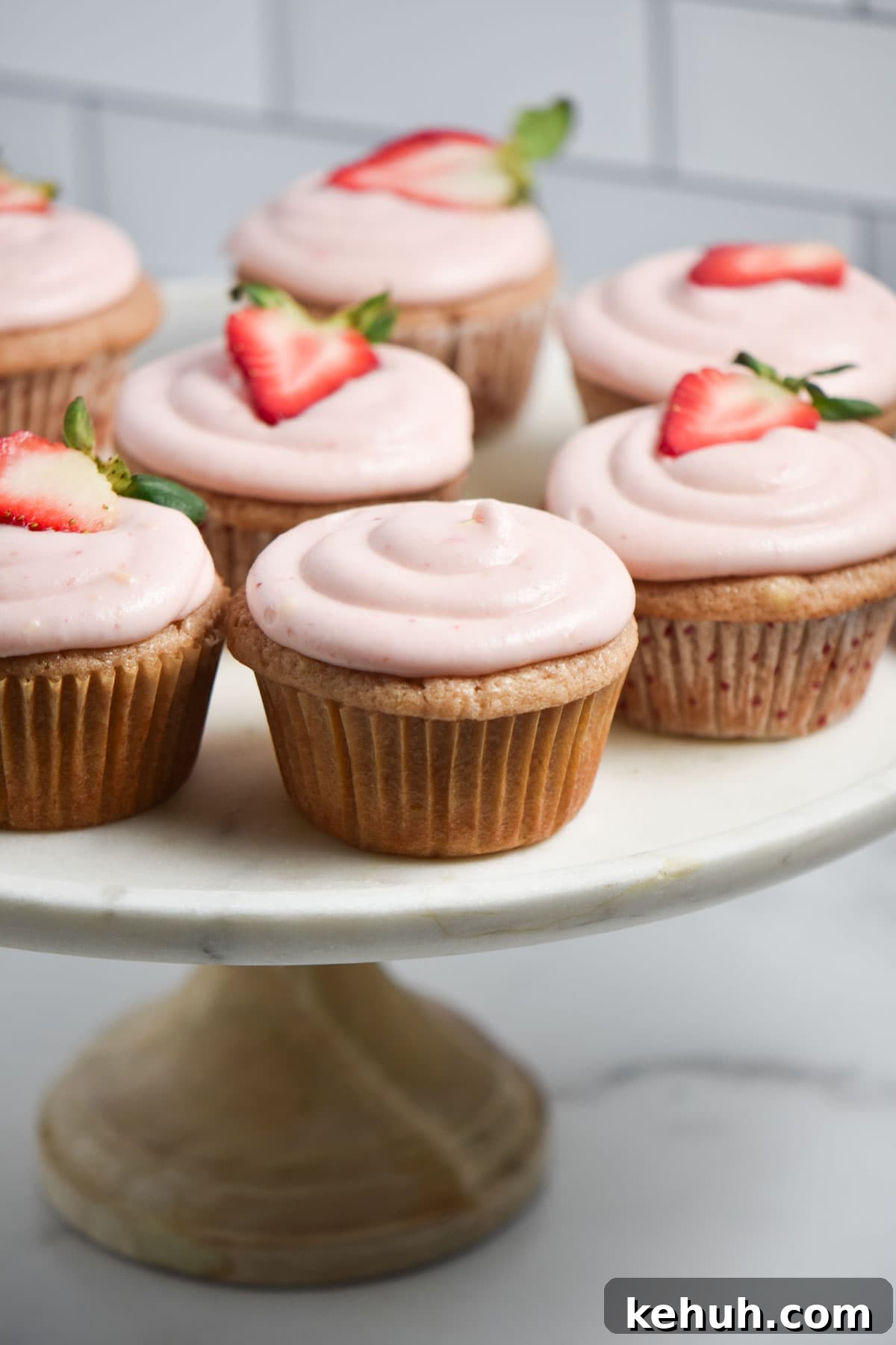 Gluten-Free Strawberry Cupcakes with Cream Cheese Frosting 6 Cream cheese frosting on a cupcake, some being topped with a fresh strawberry slice.