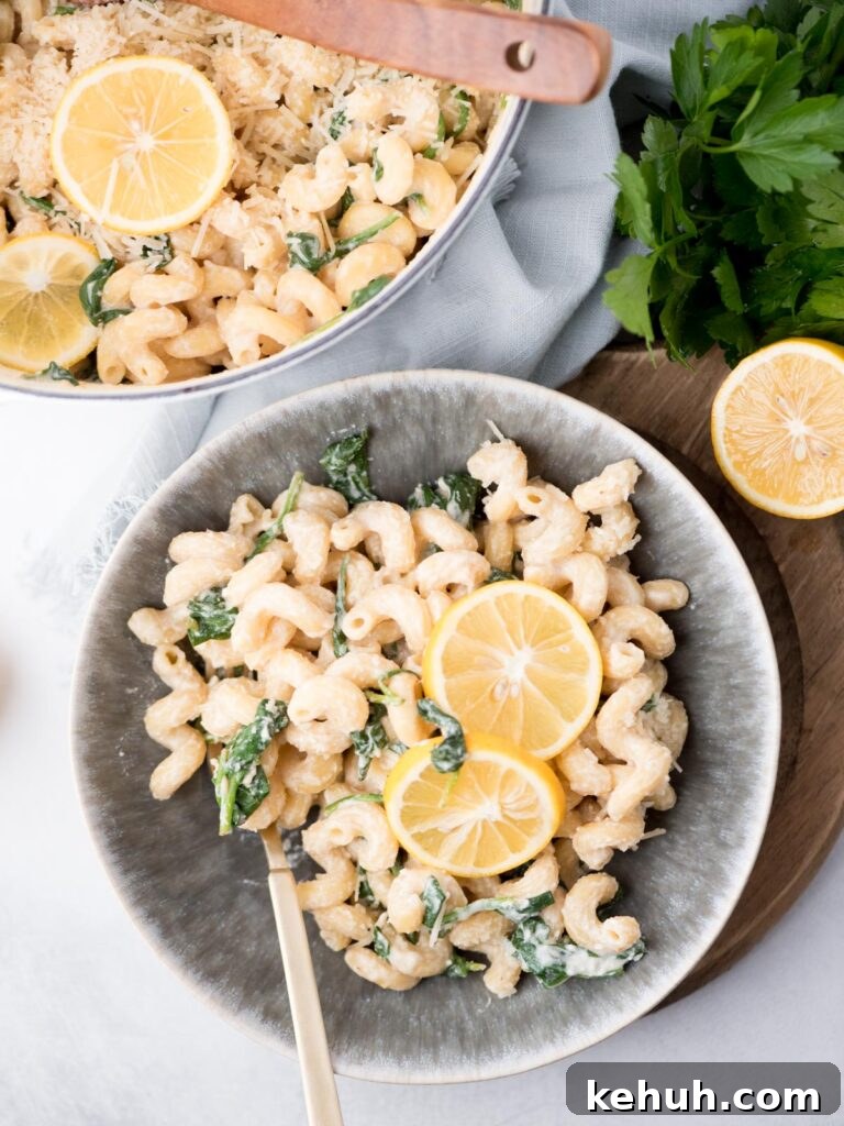 Top view of a bowl with lemon ricotta pasta and 2 lemon round garnishes in the middle.