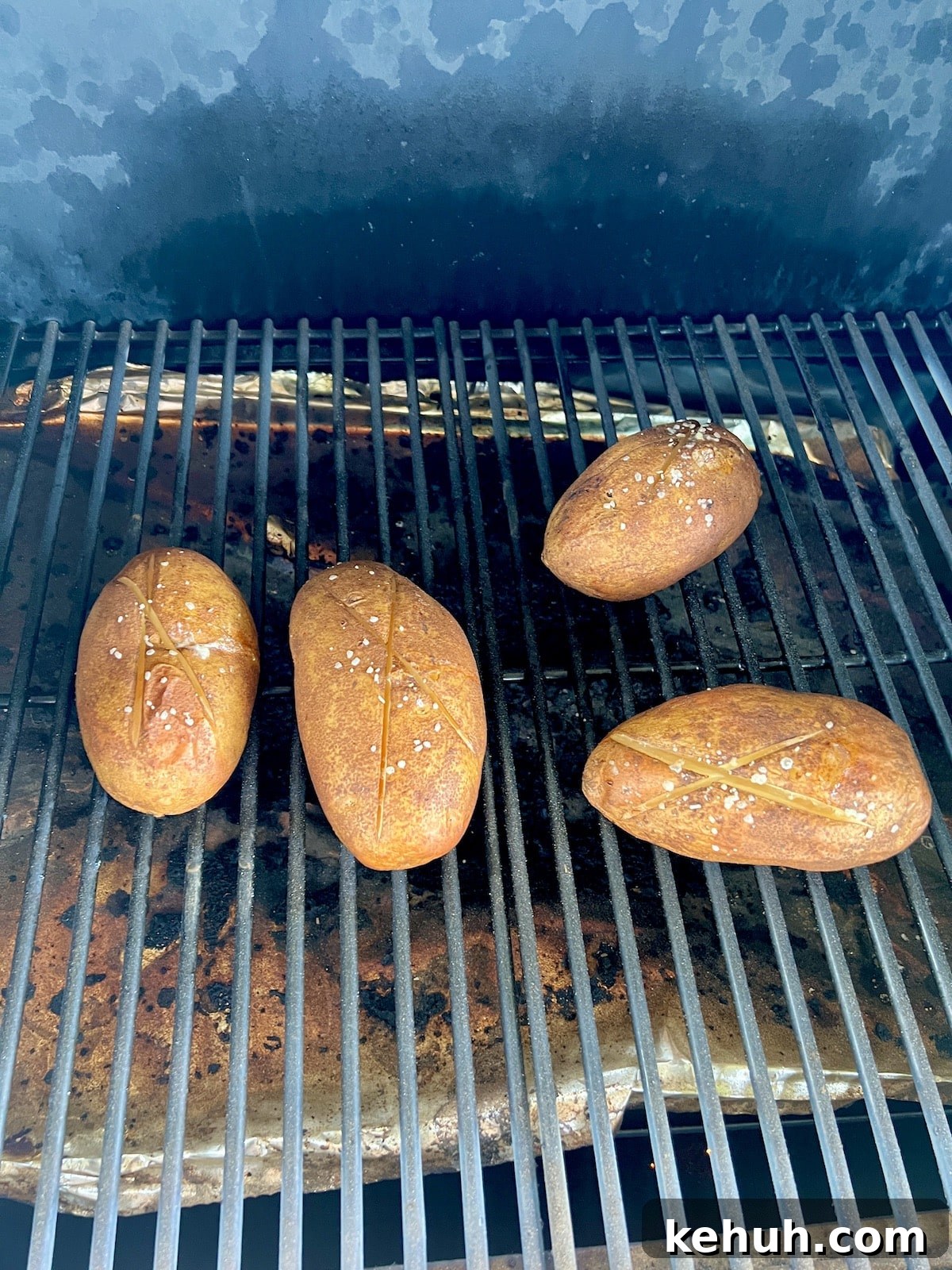 Cooking four baked potatoes on a pellet grill.