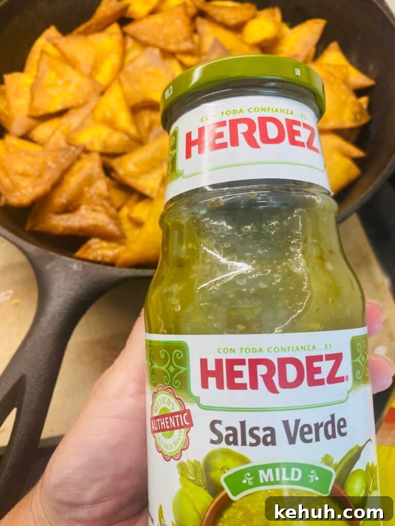 adding the green salsa to the chips
