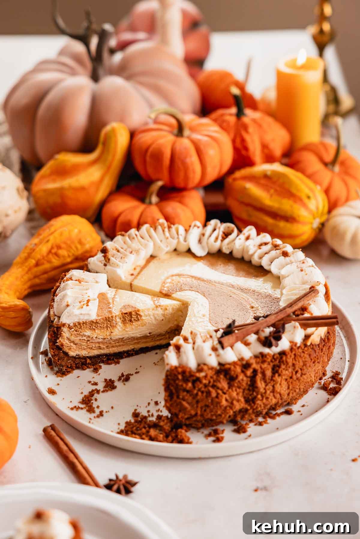Pumpkin Swirl Cheesecake Recipe: Creamy Autumn Dessert 11 sliced pumpkin pie cheesecake on cake plate with whipped cream