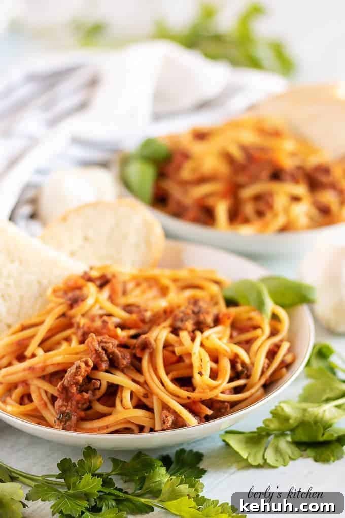 Final large photo of the beef bolognese served with fresh baked bread.