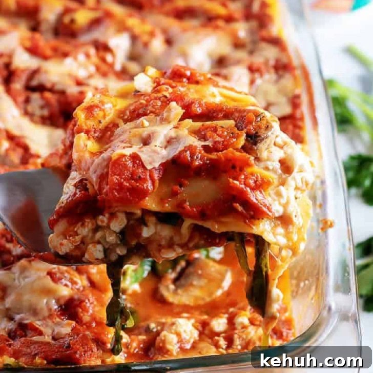 Slice of mushroom lasagna being held up from the pan.