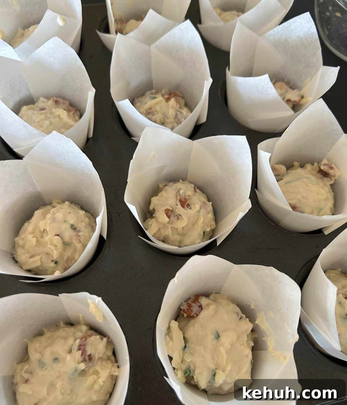 Cheesy Bacon Muffins: Savory Breakfast & Snack Recipe 8 Batter in liners in muffin tin.
