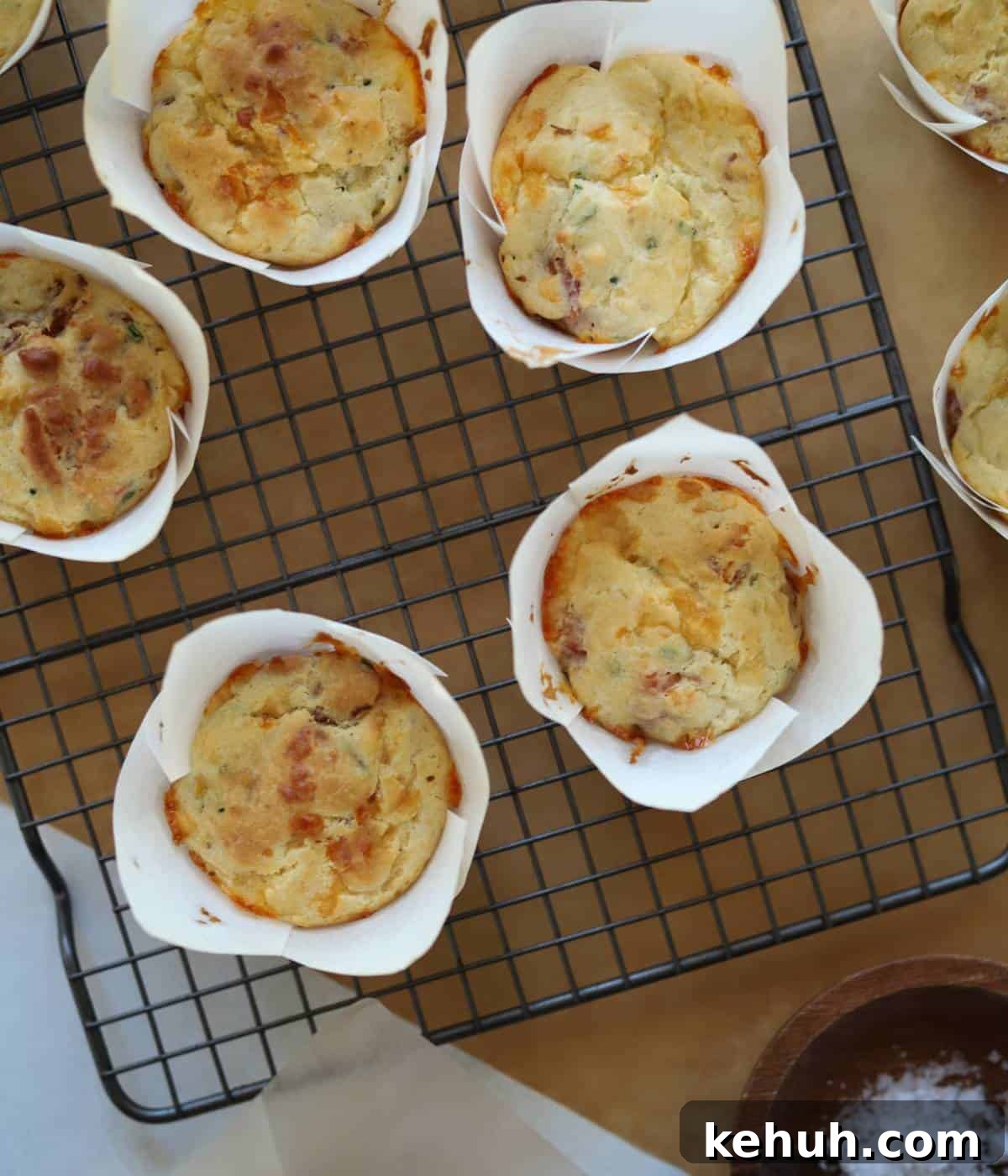 Cheesy Bacon Muffins: Savory Breakfast & Snack Recipe 9 Bacon muffins in tulip liners on baking rack.