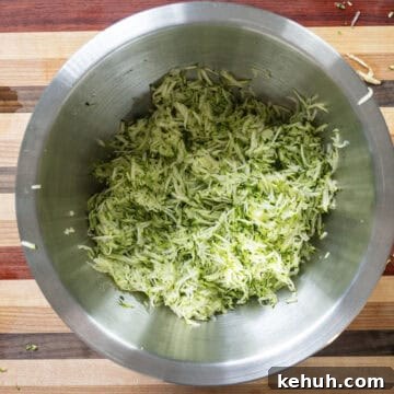Crispy Air Fryer Zucchini Fritters Recipe 4 Grated zucchini in a bowl.
