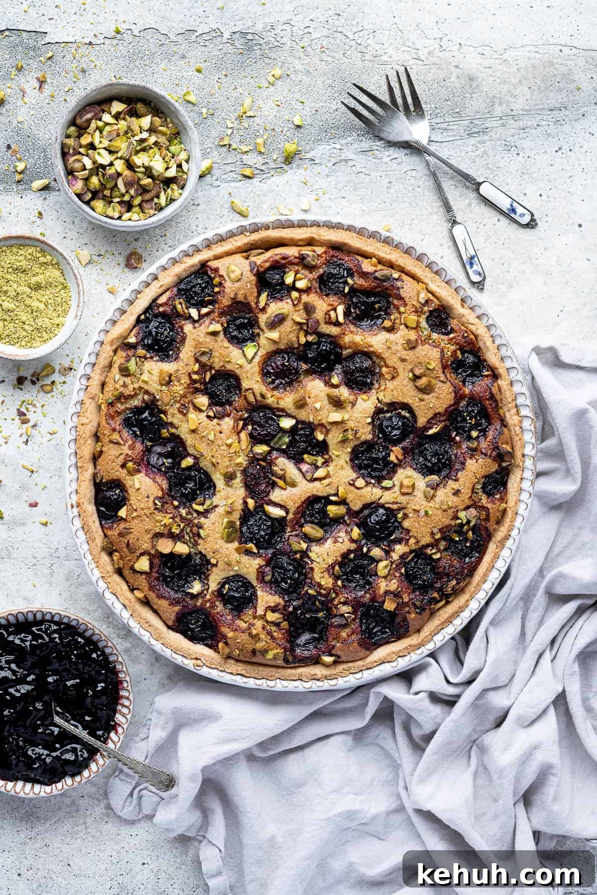 Vegan Pistachio and Cherry Frangipane Tart Recipe 2 Pistachio cherry frangipane tart with bowls of cherry jam, pistachios and ground pistachios.