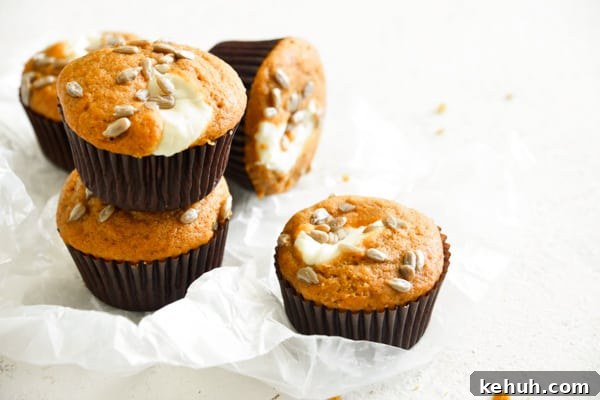 Pumpkin Cream Cheese Muffins stacked on a white board. 