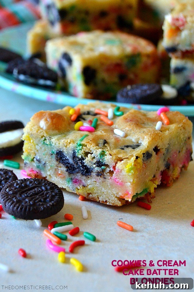 Cookies and Cream Cake-Batter Blondies: Decadent No-Fuss Treat 2 Single cookies & cream cake batter blondie on white wood with sprinkles and oreos