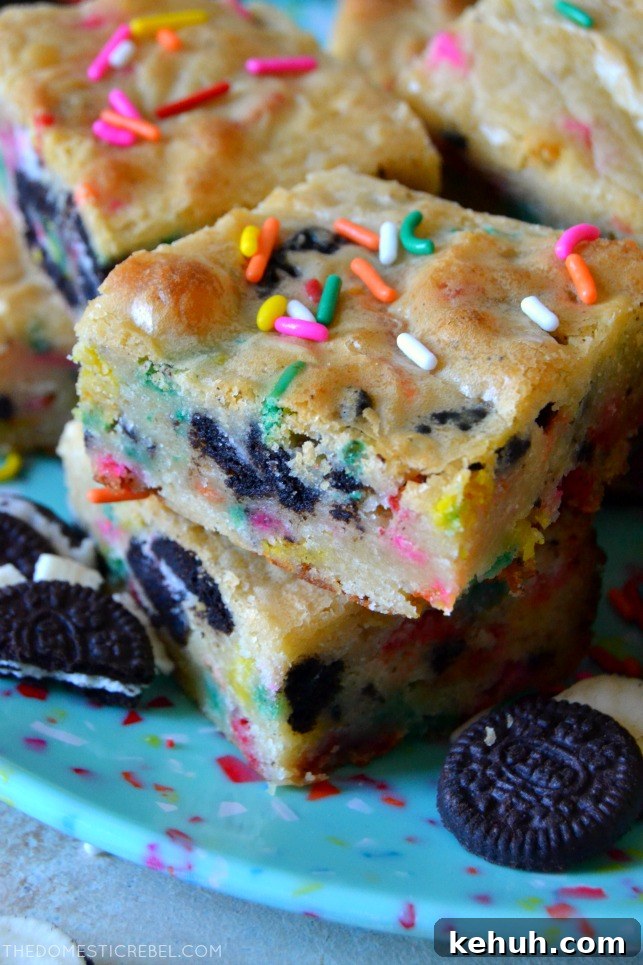 Cookies and Cream Cake-Batter Blondies: Decadent No-Fuss Treat 4 Small stack of two cookies & cream cake batter blondies on blue plate with mini Oreos