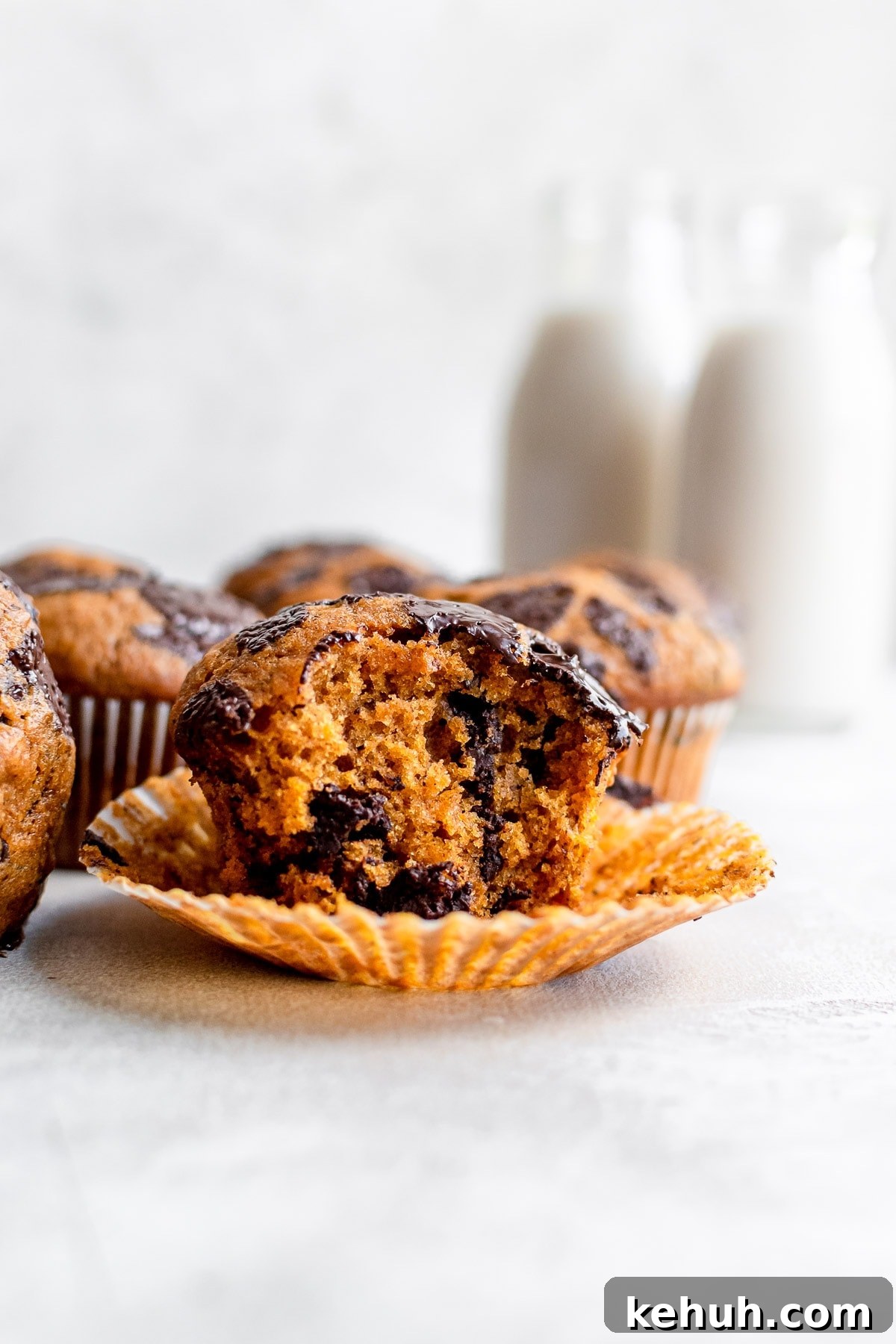 close up of pumpkin muffin in wrapper with bite missing