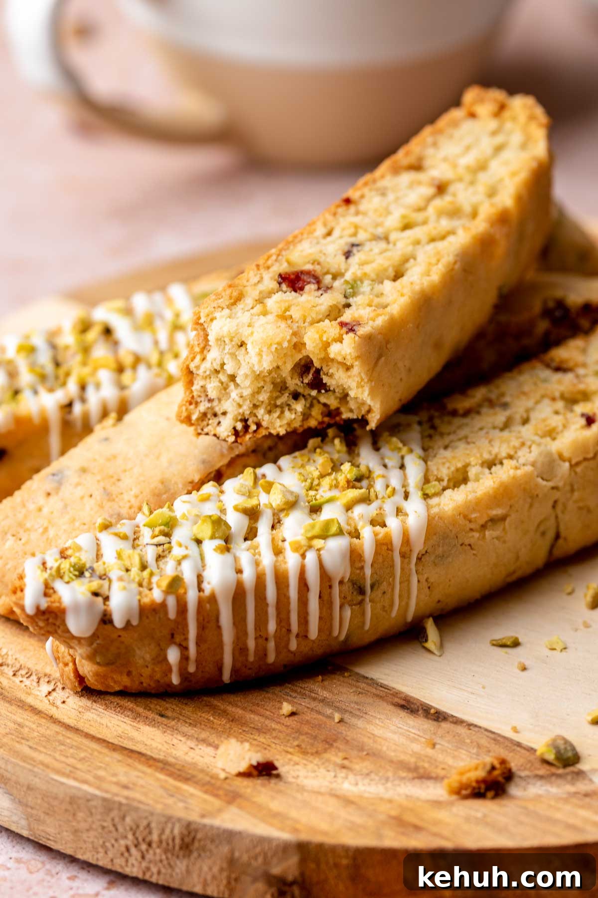 Pieces of cranberry pistachio biscotti on a plate. One is broken in half.