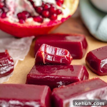 Pomegranate caramels on a platter. One has a bite removed.